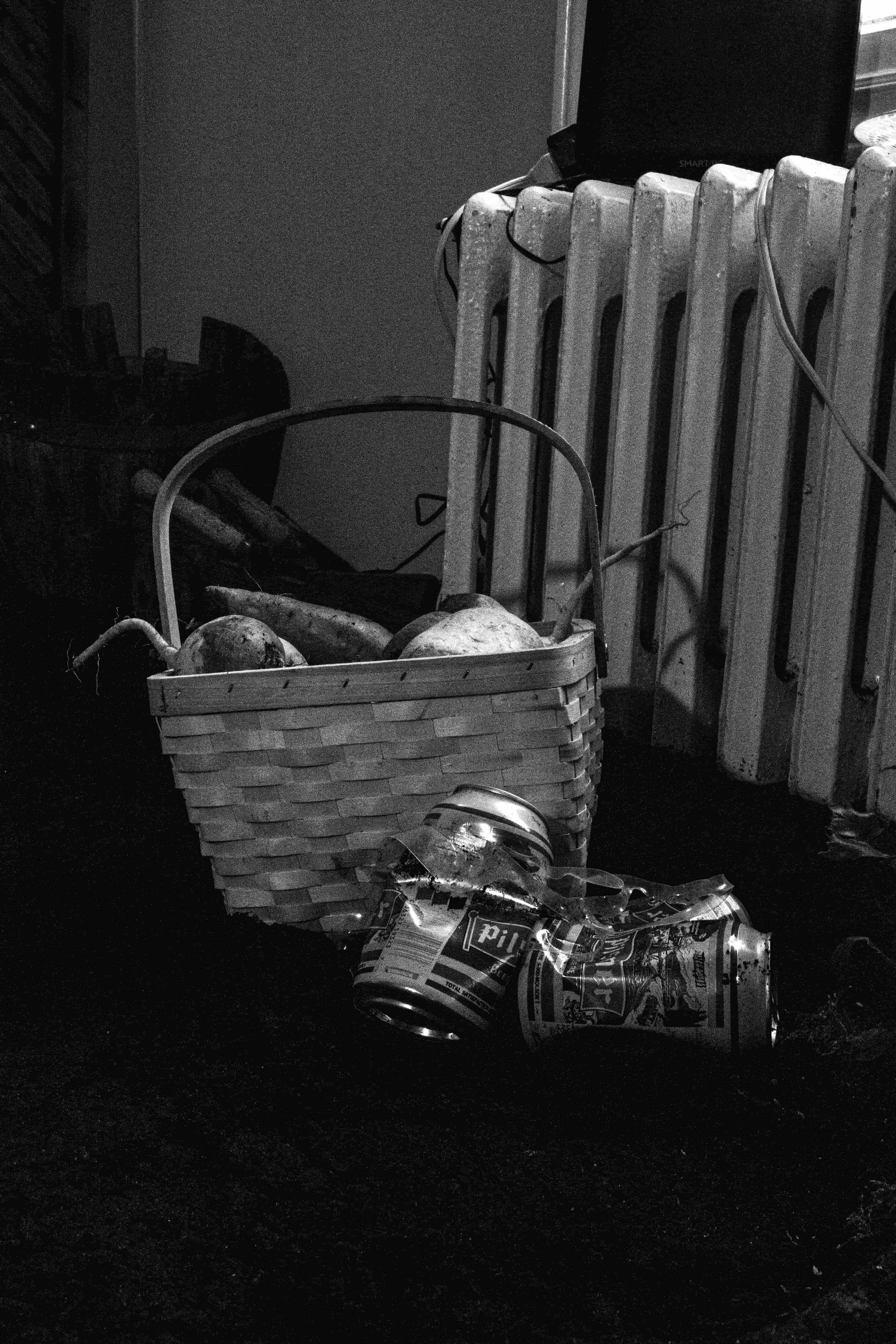 Produce from the farm sits in a wicker basket, surrounded by beer cans in the living room garden